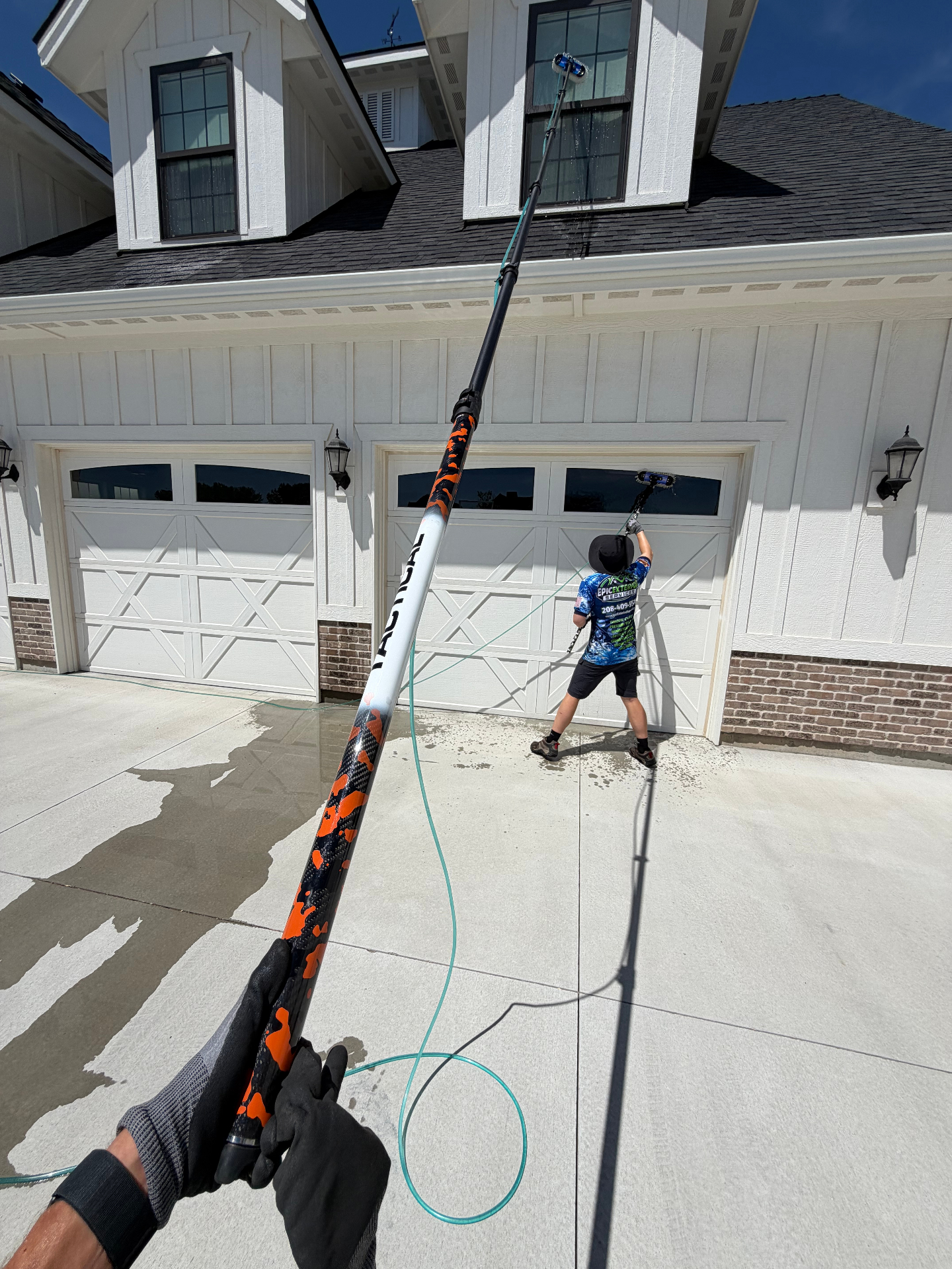 Epic Exterior Services technician cleaning second-story windows on a Meridian, Idaho home