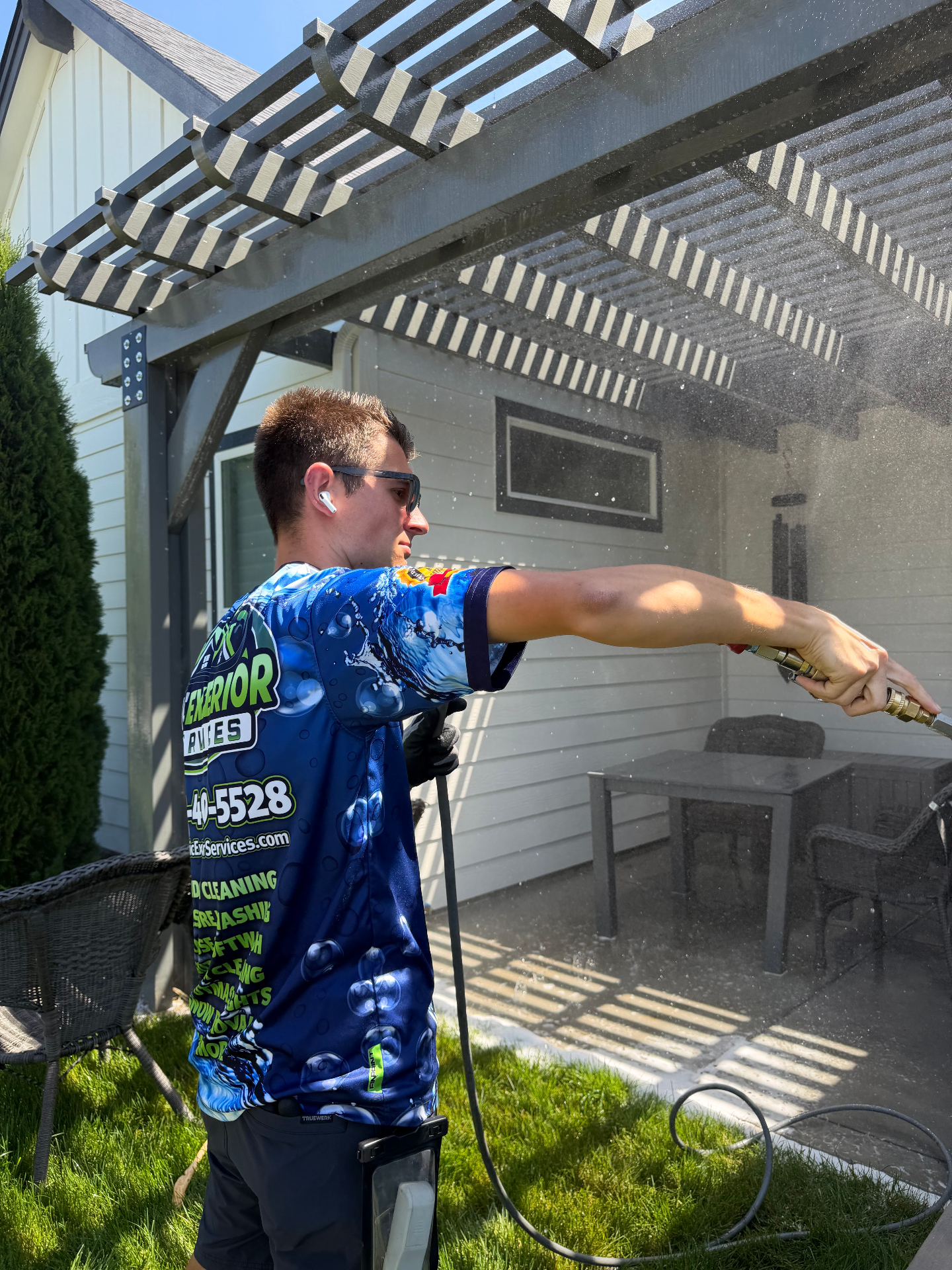 Epic Exterior Services technician soft washing under a pergola in Eagle, Idaho