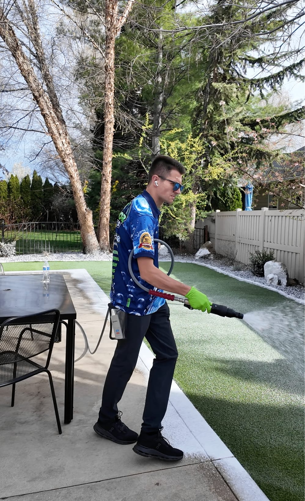 Epic Exterior Services technician rinsing artificial turf with specialized equipment